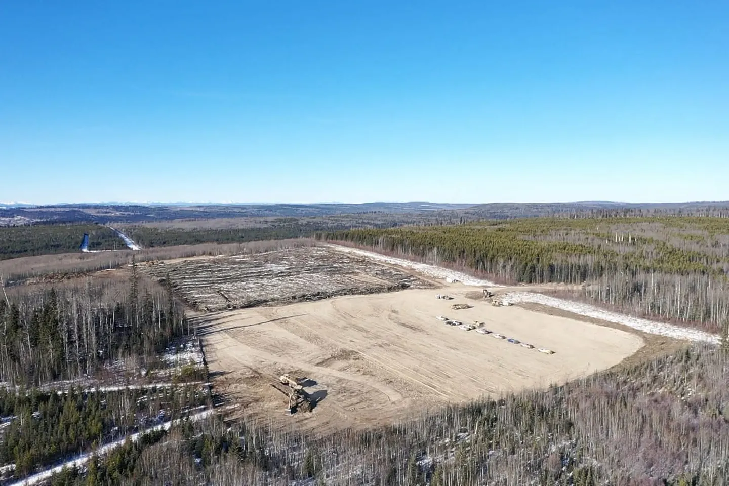 Aerial view of a finished lease pad surrounded by standing timber
