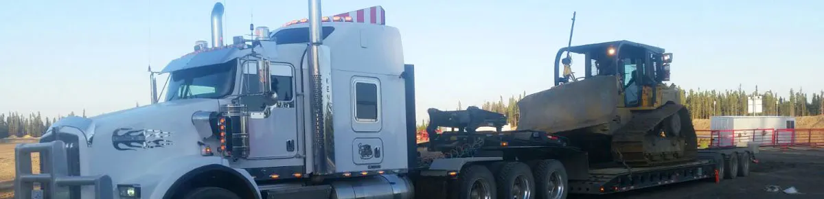 Kenworth tractor hauling a dozer on a double drop low bed trailer