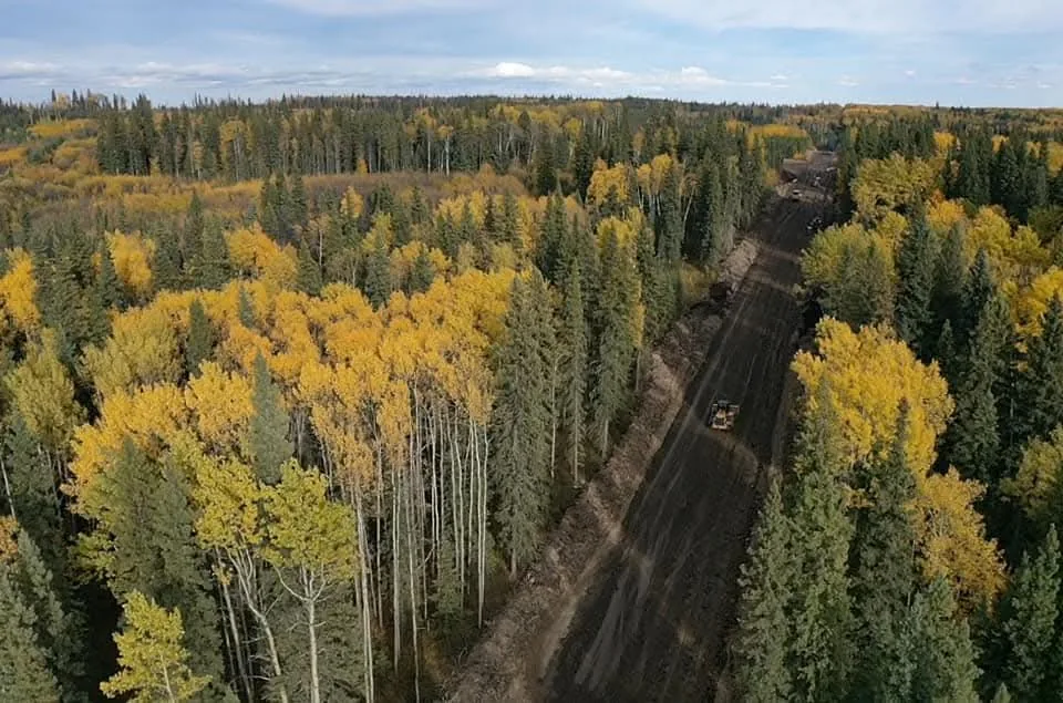 Aerial view of a dozer working a right of way bordered by yellow aspen