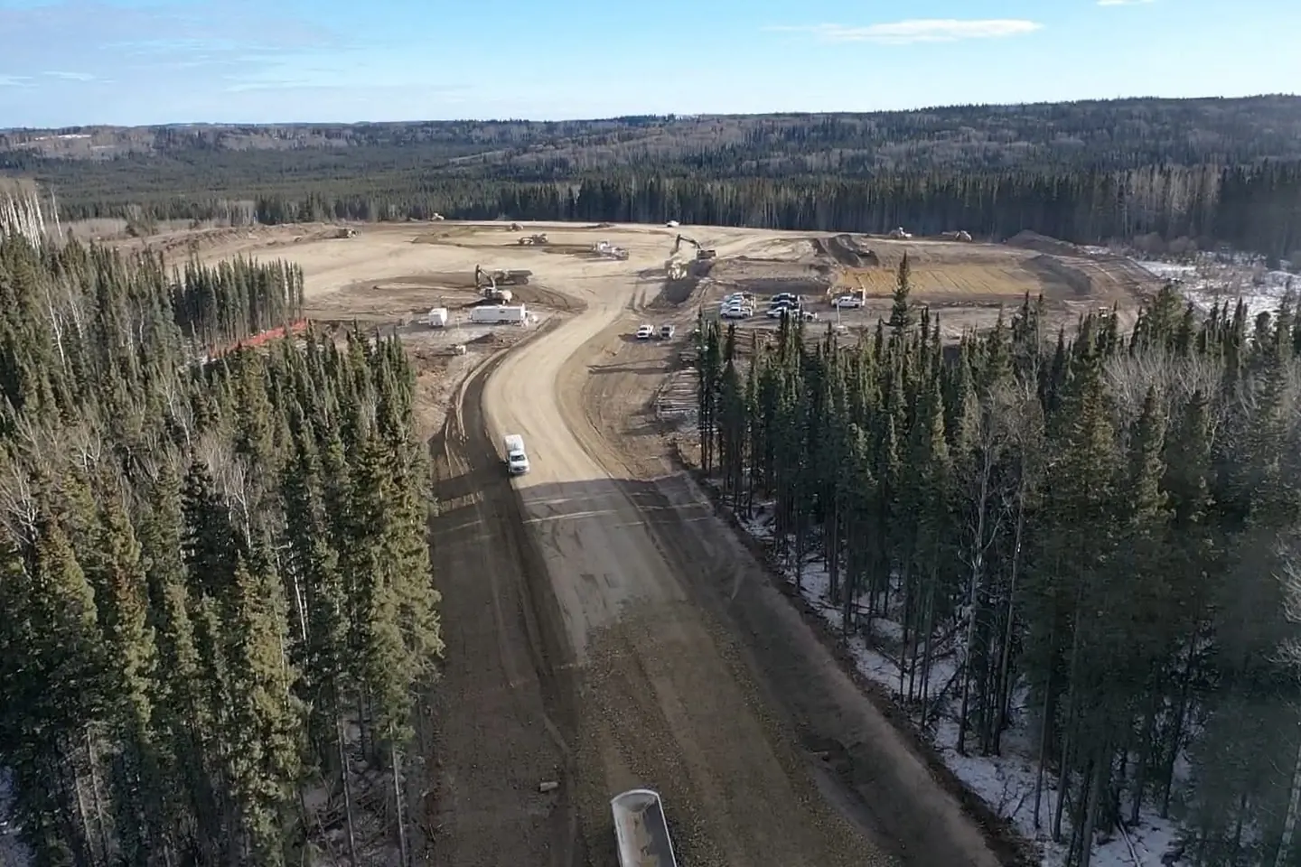 Aerial view of a gravel access road leading to a pad under construction