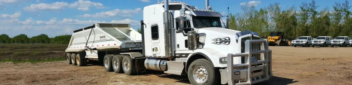 Kenworth tractor with a belly dump trailer on a gravel yard