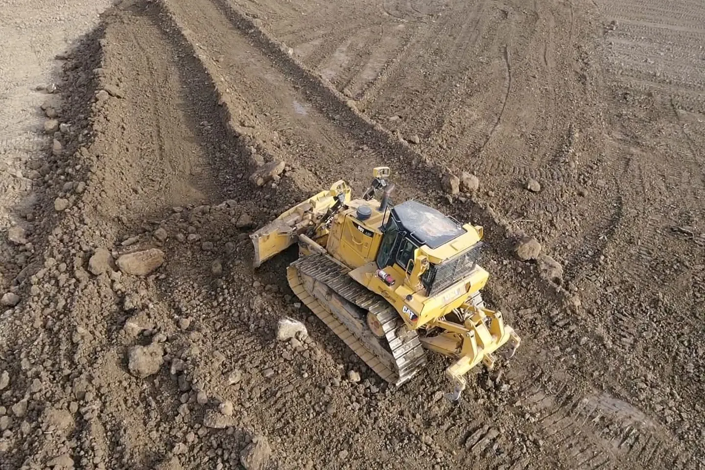 Cat D9T dozer with rear rippers pulling material across a subgrade