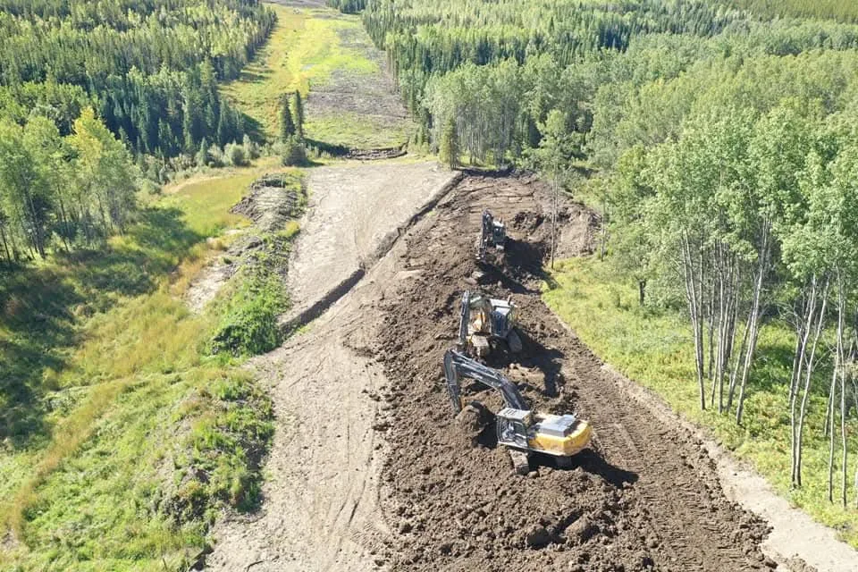 Aerial view of two tracked excavators moving spoil along a pipeline trench
